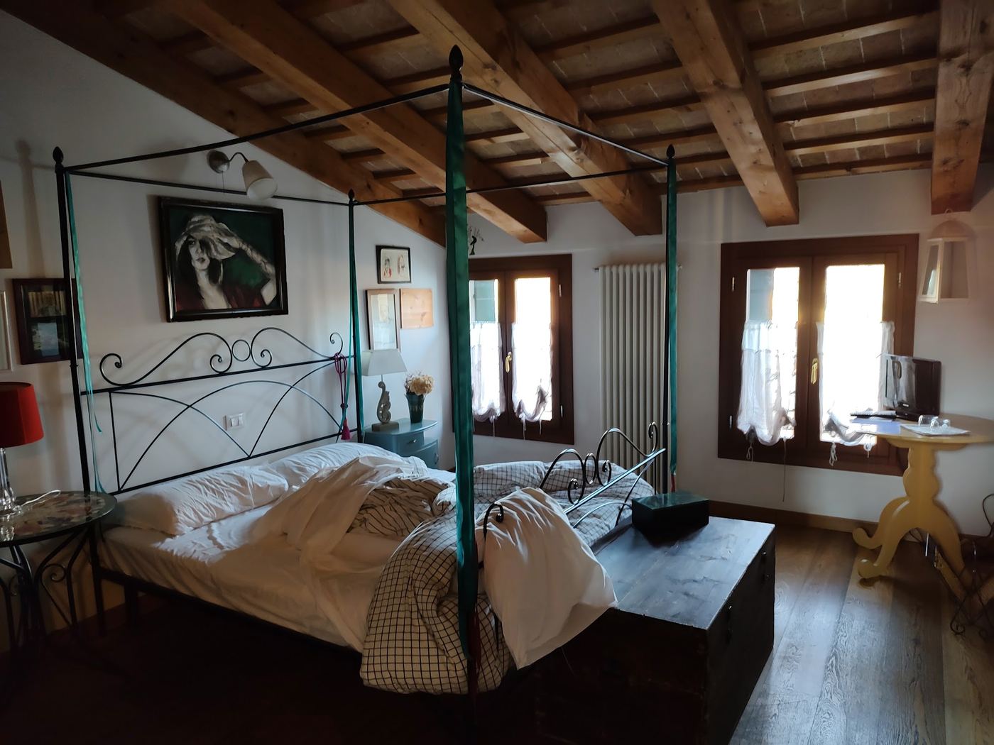 Camera con letto in ferro battuto e soffitto con travi