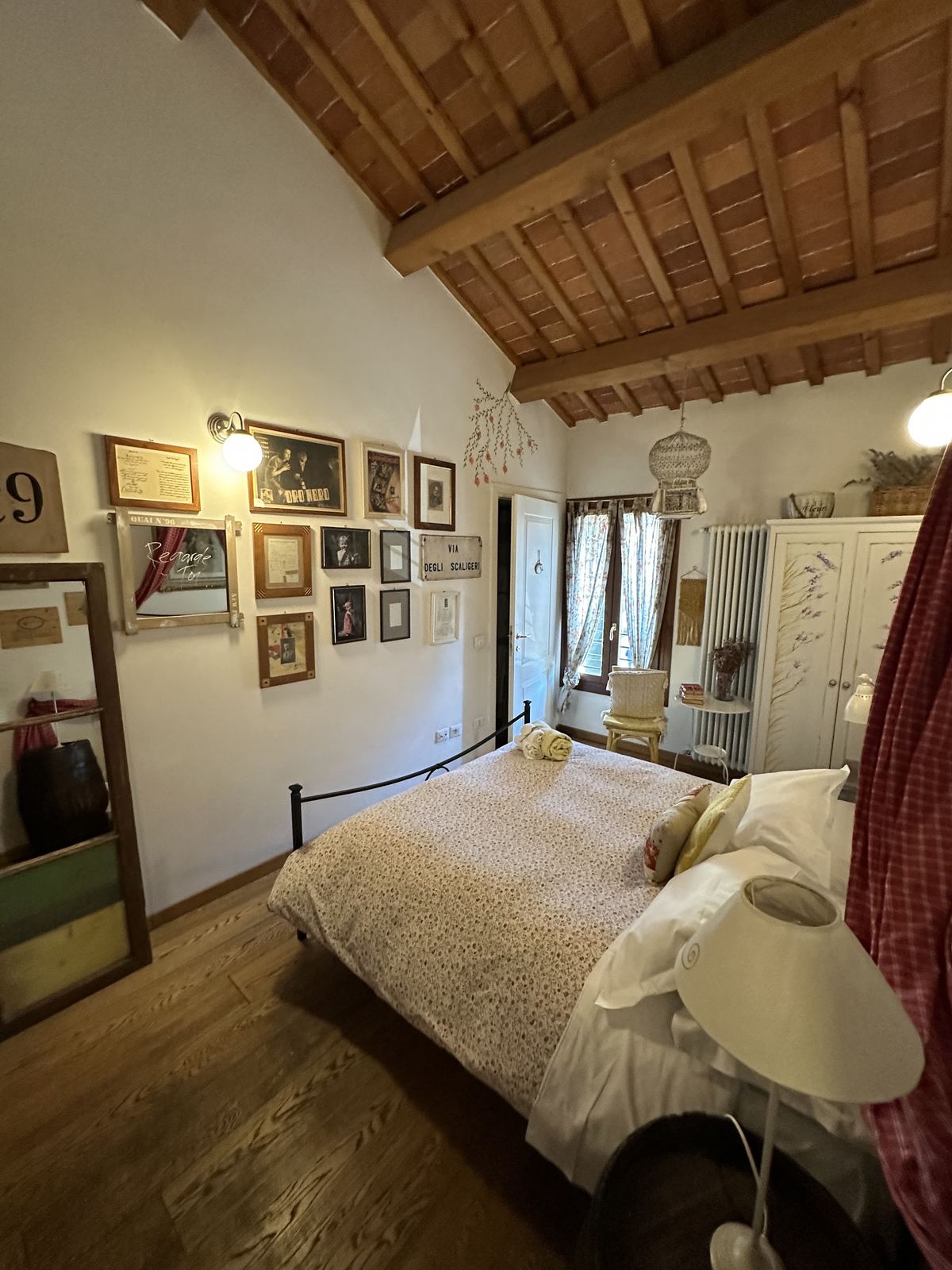 Camera con parete di cornici e letto matrimoniale