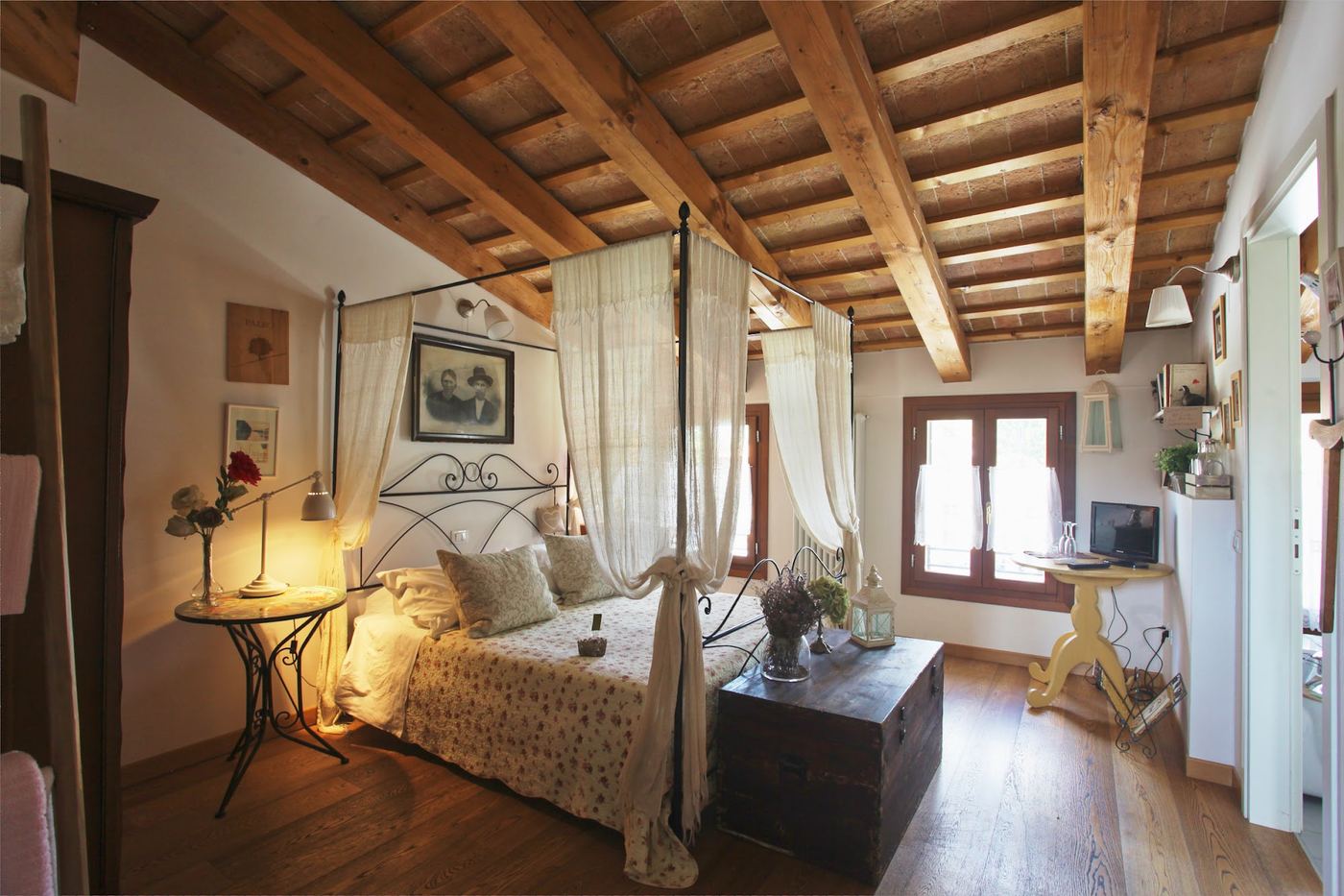 Camera con letto a baldacchino illuminata da lampade calde