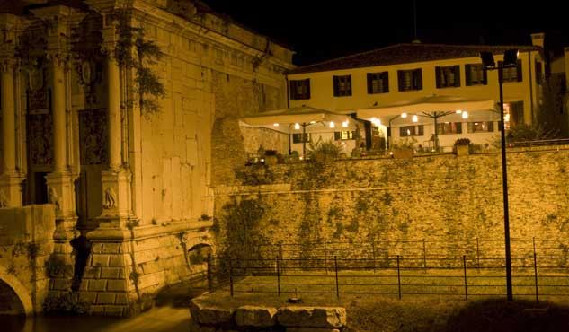 La Locanda illuminata di notte sopra le mura, accanto a Porta San Tomaso